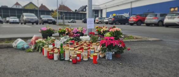 Die Trauer um den getöteten 16-Jährigen aus Lemgo ist auch am Mittwoch anhand von Blumen und Grablichtern auf dem Parkplatz des Edekas in Lemgo zu erkennen. - © Janet König