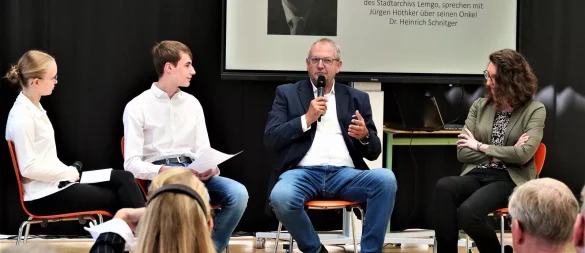 Unter einem der wenigen Fotos seines Onkels beantwortet Jürgen Höthker (Dritter von links) im Beisein von Julia Plötzgen (rechts) Schülerfragen. - © Jörg Hagemann