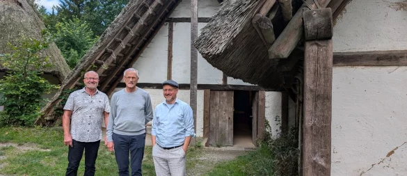 Klaus Stein, Geschäftsführer des Archäologischen Freilichtmuseums, Moritz Ilemann, Vorsitzender des Trägervereins und Museumsleiter Karl Banghard vor dem mittleren der drei germanischen Häuser. Das soll ersetzt werden durch ein in zwei Hälften geteiltes Haus, in dem das nationalsozialistische Germanenbild dem tatsächlichen gegenübergestellt wird. Foto: Gunter Held - © Gunter Held