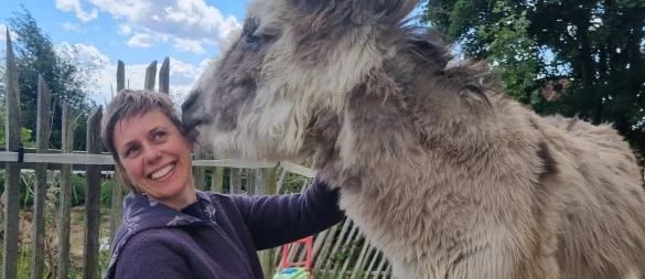 Beata Langkau freut sich über einen Schmatzer von Esel "Huckepack". - © Kirsten Fuhrmann