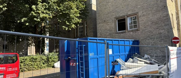 Ein Container für entkerntes Material steht vor dem Anbau auf der Rückseite des historischen Rathauses. Dieses Gebäudeteil, das aus den 1960er Jahren stammt und nicht unter Denkmalschutz steht, wird in Kürze abgerissen. - © Thomas Reineke