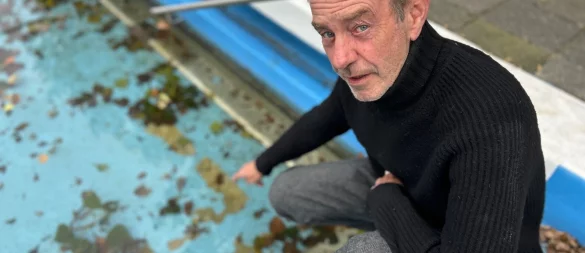 Pächter Franz-Josef Füchtenschnieder zeigt aufgeplatzte Farbbereiche am Beckenboden im Gütersloher Parkbad. Rund 50 dieser Stellen hat er gezählt. - © Christian Bröder