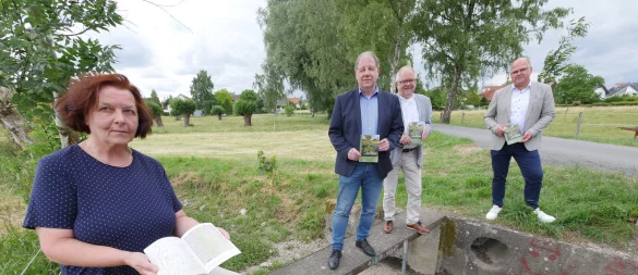 Annette Fischer, Autorin der "Lippischen Kulturlandschaften" zum Thema Flößwiesen in Schlangen, steht gemeinsam mit Dr. Stefan Wiesekopsieker (Lippischer Heimatbund, von links), Heinz Kriete (Heimatverein Schlangen) und Bürgermeister Marcus Püster auf den Resten eines Stauwehrs an den Niederen Knickwiesen. Im Hintergrund: eine ehemalige Flößwiese. - © Jost Wolf
