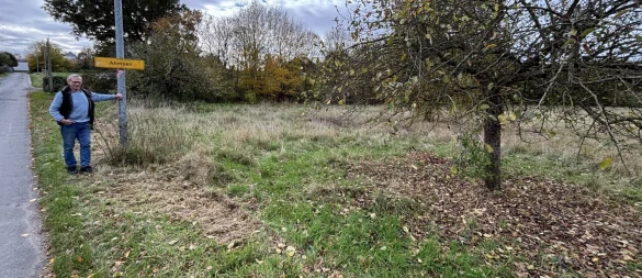Anwohner Folker Scheuermann steht an der kleinen Straße „Zur Werre“ an der vor gut einem Vierteljahrhundert angelegten Streuobstwiese. Er kritisiert den Zustand der Grünfläche. - © Thomas Reineke