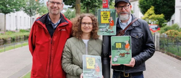 Auch am Wall erinnert ein neues Schild jetzt freundlich daran, dass es sich ohne die Hinterlassenschaften der Vierbeiner einfach schöner in Detmold spazieren gehen lässt. (von links) Stephan Szymanowski und Inga Müller aus dem Team Freiraumplanung der Stadt Detmold und den Detmolder Cartoonisten André Sedlaczek. - © Torben Gocke