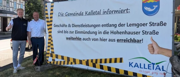 Geschäftsinhaber Jannis Röthemeier (links) und Bürgermeister Mario Hecker prüsentieren das Banner vor dem Kalletaler Rathaus. - © Gemeinde Kalletal