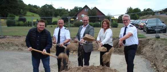 Projektleiter Florian Kenter (von links), Barntrups Feuerwehr-Chef Stefan Jakob, Bürgermeister Borris Ortmeier, Planerin Marina Klippenstein und Christian Meier, Einheitsführer in Sonneborn, machen den symbolischen ersten Spatenstich. Im Hintergrund ist schon die Fläche für den Anbau zu sehen. - © Nadine Uphoff
