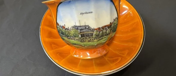 Eine Souvenirtasse aus den 1940er-Jahren, auf der das Kurhaus nach dem Anbau der runden Terrasse zur Kurparkseite abgebildet ist. - © Sven Kienscherf