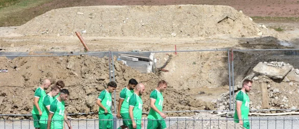 Vorbei an der größten Baustelle geht es für die Spieler der TuS Helpup zum Rasenplatz, hier entsteht das neue Sporthaus. Im Hintergrund ist der Hartplatz zu sehen. - © Oliver König