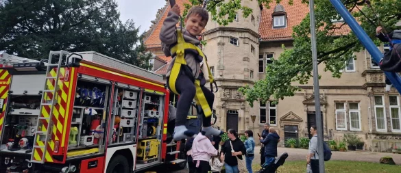 Der dreijährige Abud liebt das Trampolin-Springen vor dem Schloss. Im Hintergrund ist die Feuerwehr zu sehen, die ihr Löschfahrzeug mitgebracht hat, damit es sich die Kinder aus nächster Nähe anschauen können. - © Nadine Uphoff
