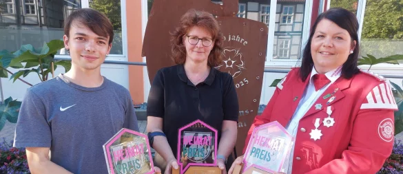 Lukas Gansler (von links, Leiter des Kellertreffs der Kolpingsfamilie Lügde), Anke Weber (Schriftführerin des Heimat- und Verkehrsvereins Falkenhagen) und Lena Wolff (Vorsitzende des Spielmannszuges Elbrinxen) haben die Heimatpreise für ihre Vereine entgegengenommen. - © Michaela Weiße