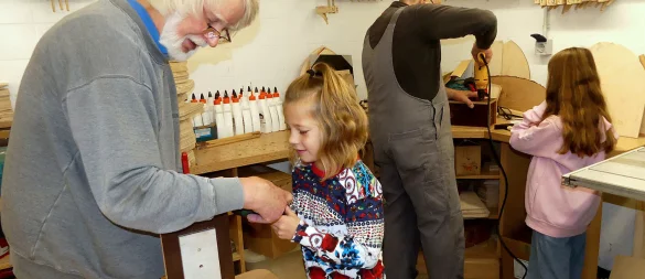 Herbert Doedecke arbeitet mit Emma zusammen, während im Hintergrund Andreas Krüger und Jette an einem Nistkasten werkeln. - © Rudi Rudolph