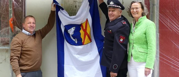 Bürgermeister Mario Hecker (von links), Ex-Löschgruppenführer Herbert Bröker und Ministerin Ina Scharrenbach enthüllen das Wandrelief aus der früheren Feuerwache. - © Rudi Rudolph