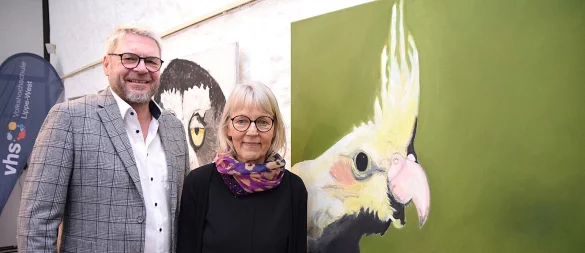 Bürgermeister Peter Heepmann eröffnet die Ausstellung von Marie-Anna Flüchter-Steffen im Bürgerhaus. Beide stehen vor einem der Lieblingsbilder der Künstlerin, einem Nymphensittich, der gute Laune ausstrahlt. Foto: Karin Prignitz - © Karin Prignitz