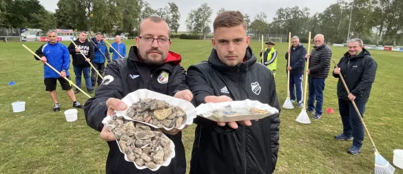 Timo Lenniger (links) und Erik Tappe zeigen einen Teil der Steine, Scherben, Plastik- und Metallstücke, die Mitglieder des VfL Lieme bereits vom Sportplatz geklaubt haben. Am Dienstag wurde die Aktion abgebrochen, man kapituliere vor der unmöglichen Aufgabe, heißt es von Seiten des Vereins. - © Till Brand