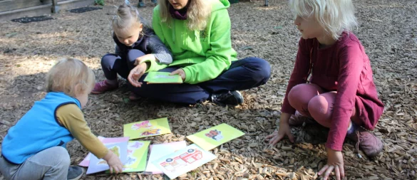 Kita-Leiterin Marina Balz sucht mit den jüngsten Waldfrüchtchen Neo (links) und Linea verschiedene Liedkarten aus. Das finden auch die älteren Kita-Kinder wie Marie (rechts) interessant. - © Susanne Grimm