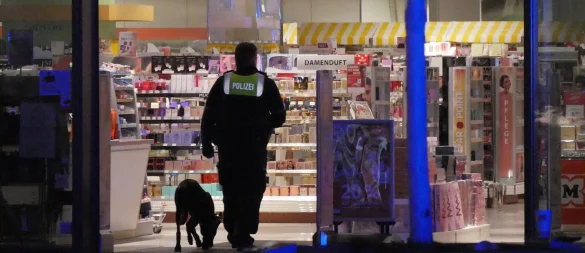 Mit einem Spürhund kontrolliert die Polizei nach Auslösung der Diebstahlwarnanlage im Müller, ob noch Personen im Geschäft sind. - © Jost Wolf