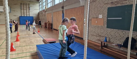 Shyrin (links) und Luisa versuchen, den Ball über den Parcours zu balancieren - ohne ihn mit den Händen zu berühren. - © Nadine Uphoff