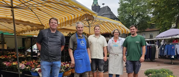 Jens Kleinehagenbrock (von links) verkauft dienstags Fisch, Detlef Schelhas Obst und Gemüse, Annett Starke Geflügel und Wild, Sebastian Hollmann Blumen und Pflanzen. Die Händler sind sich mit Marktmeister Timo Wolzin (Mitte) einig, dass der Wochenmarkt in Lage ein qualitativ hochwertiges Angebot bietet. - © Astrid Sewing