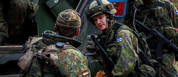 Multinationale Zusammenarbeit: Gemeinsam mit dem finnischen Zugführer klärt Kompaniechef Hauptmann Michael P. die letzten Details zur Sicherung des Versorgungsraumes ab. - © Bundeswehr/Till Hey
