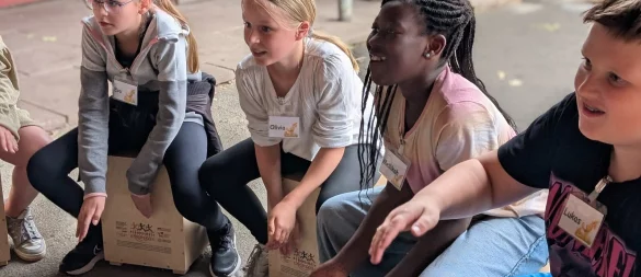 Olivia (zweite von links) in ihrem Element: Dass an der Grundschule Kirchheide jetzt Cajóns gebaut wurden, ist ihrer Initiative zu verdanken. Neben Studierenden der Holztechnik an der TH OWL beteiligte sich auch die Hochschule für Musik Detmold an der einmaligen Aktion. Die Kinder durften die Instrumente mit nach Hause nehmen. Die Teilnahme war dank mehrerer Sponsoren kostenfrei. - © Annika Langhagel