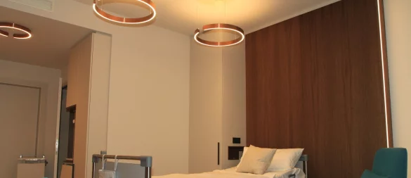Eines der Musterzimmer auf der Privatstation. Die mit Rillen verschönerten Holzoberflächen hinter dem Bett kommen weg. - © Archivbild: Martin Hostert