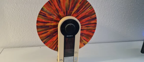 Coole Version: Dieser Plattenspieler spielt die Scheiben vertikal ab. Wenn dann auch noch ein buntes Stück Vinyl eingelegt wird, wie hier, ist der Effekt doppelt cool. - © Marianne Schwarzer