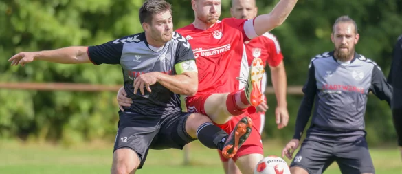 Beide Kapitäne gehen in dieser Szene mit vollem Einsatz in den Ball. Tobias Hentschel (rechts) vom TUS Bexterhagen und sein Kapitänskollege Till Meßmann vom SV Werl-Aspe kämpfen choreografisch nahezu perfekt um den Ball. - © Egon Penner