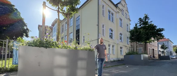 Benjamin Reichardt steht an den Blumenkübeln, die unmittelbar am Haupteingang zur Grundschule Kirchplatz an der Schülerstraße platziert sind. - © Sven Kienscherf