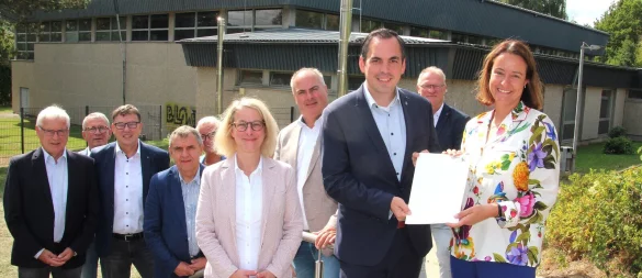 Regierungspräsidentin Anna Katharina Bölling überreicht Bürgermeister Torben Blome den Förderbescheid. Mit dabei: Schulleiterin Brigitta Wulf sowie Spitzen aus Politik und Verwaltung. - © Juliane Lehmann