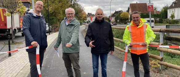 Peter Borheck (von links), Werner Gaamaa, Heinz-Dieter Krüger und Jörg Flintrop zerschneiden symbolisch das Band zur Fertigstellung der Baumaßnahme "In der Bleiche". - © Cordula Gröne