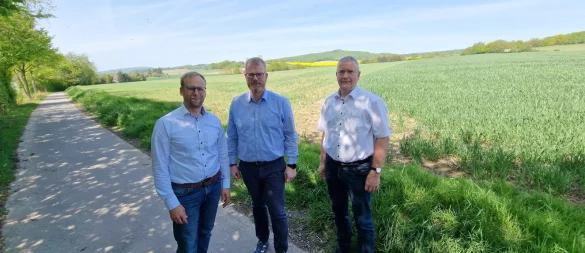 Barntrups Bürgermeister Borris Ortmeier (von links), Dörentrups Bürgermeister Friso Veldink und Extertals Kämmerer Hubertus Fricke stehen in Humfeld. Im Hintergrund ist das Gelände zu sehen, das zum interkommunalen Gewerbegebiet werden soll. - © Nadine Uphoff