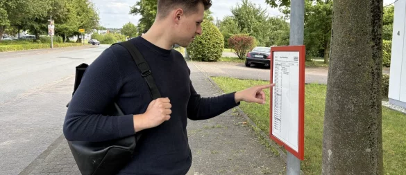 LZ-Mitarbeiter Jan Schillmann studiert an der Haltestelle "Westerfeldstraße" den Fahrplan. Er wartet auf die Buslinie 750. - © Raphael Bartling