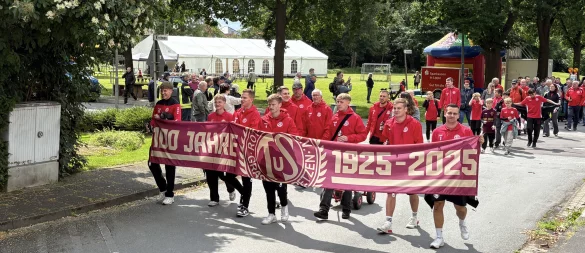 Der Festumzug des TuS RW Grastrup-Retzen. Vereinsmitglieder tragen den Banner zum 100-jährigen Jubiläum. - © Jan Schillmann