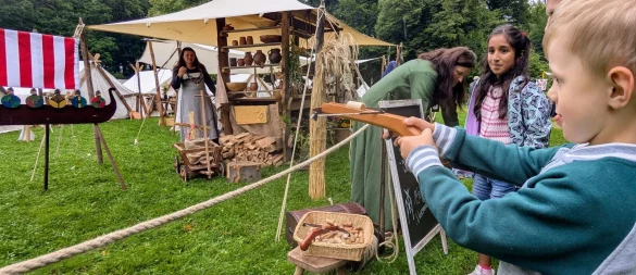 Der fünfjährige Tom Büscher probiert sich an der Armbrust, neben ihm wartet die neunjährige Vaniya Hosseini geduldig, dass sie an der Reihe ist. - © Yvonne Glandien