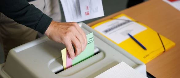 Ein Wähler wirft seine Stimmzettel in eine Wahlurne in einem Wahlraum in der Realschule Brackwede. - © Friso Gentsch/dpa