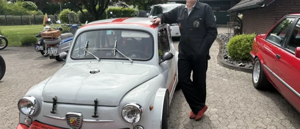 Dieter Hebrock in Rennfahrer-Montur an seinem Fiat Abarth, den er seit drei Jahrzehnten fährt. - © Jan Schillmann