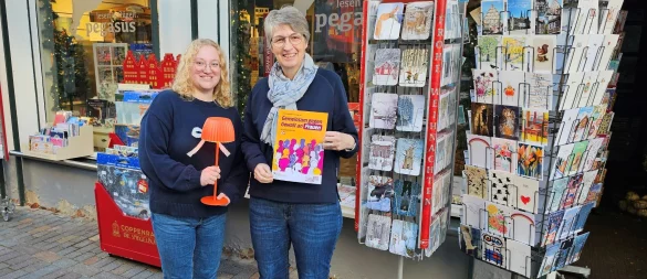 Inga Kunz (links, Inhaberin der Buchhandlung Pegasus) und Christiane Osterhage (Gleichstellungsbeauftragte der Alten Hansestadt Lemgo) setzen mit orangen Leuchten ein Zeichen gegen Gewalt gegen Frauen und Mädchen. - © Stadt Lemgo