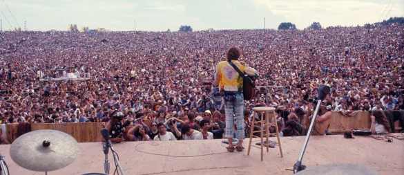 Das legendäre Bild. Es zeigt den fast einsamen Musiker John Sebastian vor 500.000 Besuchern auf der "Woodstock-Wiese". - © Henry Diltz