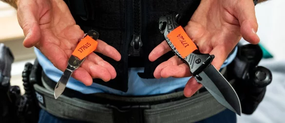 Ein Polizist zeigt sichergestellt Messer. Die Sicherheitsbehörden setzen aktuell immer wieder auf „individuelle Messerverbote“, um potenziell gefährliche Personen zu entwaffnen. - © Daniel Bockwoldt/dpa