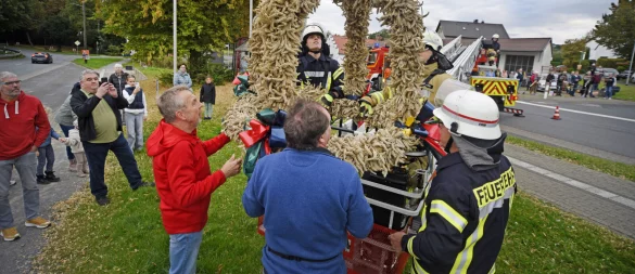 Mit Hilfe der Feuerwehr wurde die Erntekrone aufgehängt. - © Nicole Ellerbrake