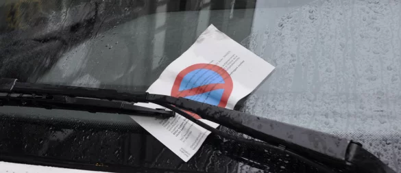 Ein Strafzettel auf einer nassen Windschutzscheibe sorgt in Bad Meinberg für Diskussionen über Parkverbot und Kontrollen beim Bauernmarkt. - © Symbolbild: preisvergleich.de