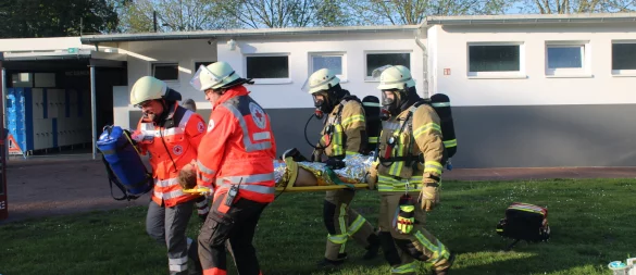 Die "verletzte" Freibad-Mitarbeiterin wird von Einsatzkräften aus dem Gefahrenbereich getragen. - © Daniel Hobein/Freiwillige Feuerwehr Bad Salzuflen