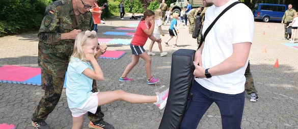 In der zuvor trainierten Abwehrhaltung tritt Julie (7) gegen eine dicke Matte, die von ihrem Papa Waldemar Benks gehalten wird. Foto: Karin Prignitz - © Karin Prignitz