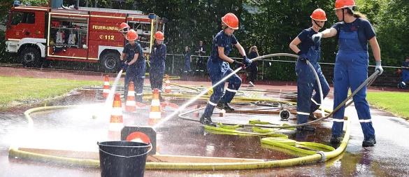 Jugendliche vom Team Detmold-Süd, die später den dritten Platz belegen, versuchen, mit dem Wasserschlauch Bälle über Hindernisse ins Ziel zu befördern. Foto: Karin Prignitz - © Karin Prignitz