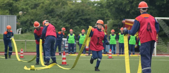 Die Jugendlichen müssen die Feuerwehrschläuche aneinander kuppeln. - © Daniel Hobein