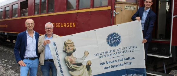 Frank Budde (Stiftung Denkmalschutz, von links) und Holger Brokemper ("WestLotto") stehen mit Betriebsleiter Raphael Kahlert vor dem historischen Speisewagen aus dem Jahr 1936. - © Lorraine Brinkmann