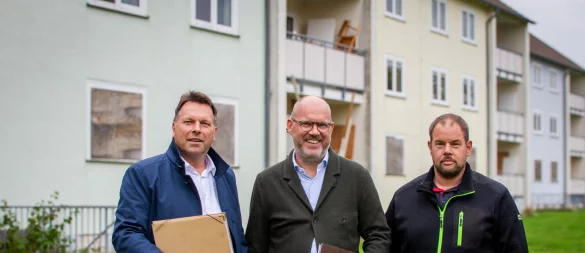 Detmolds Bürgermeister Frank Hilker, Michael Kirchner (Vorstand Breitefeld eG) und Sebastian Brummel (Abbruch Landwehr) stehen im "Adenauerpark". Die Gebäude im Hintergrund werden in Kürze abgerissen. Hier entstehen mehrere energieeffiziente Neubauten. - © Raphael Bartling