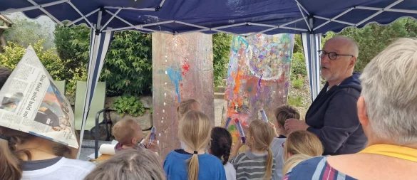 Künstler Kurt Trometer zeigt den Kindern, wie sie mit den Farbspritzen umgehen müssen. - © Nadine Uphoff