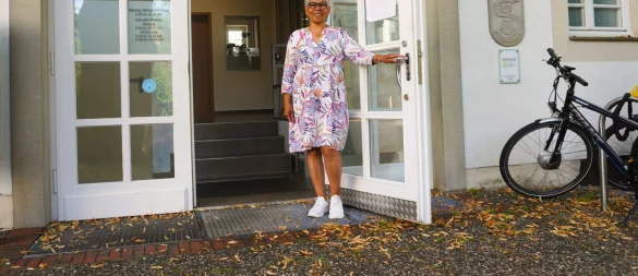 Malita Makoza hält die Tür auf. Jahrelang hieß sie Menschen in Schlangen willkommen. - © Gemeinde Schlangen